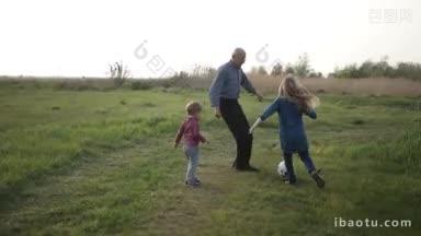 多代家庭在郊外玩得很开心英俊的爷爷教孙子在绿色的草坪上踢足球